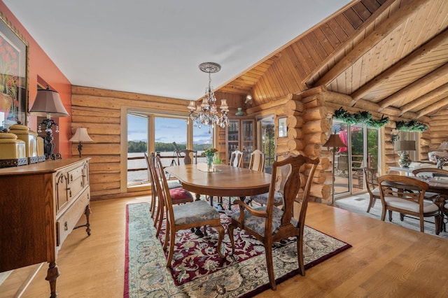 30047 Sunny Beach Rd, Grand Rapids, MN 55744 - dining space featuring log walls, a chandelier, light wood-style floors, and lofted ceiling