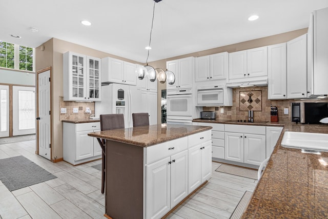 14217 Footbridge Way, Apple Valley, MN 55124 - kitchen featuring decorative backsplash, a center island, glass insert cabinets, white appliances, and recessed lighting