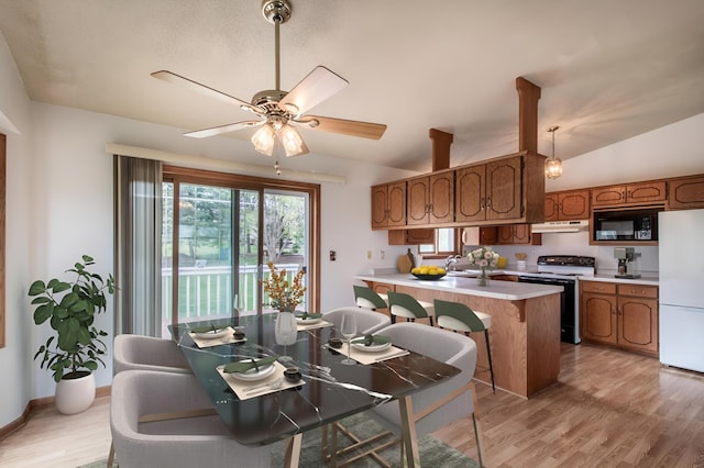 kitchen with electric range, black microwave, light countertops, freestanding refrigerator, and under cabinet range hood