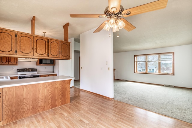 kitchen featuring exhaust hood, light countertops, visible vents, and electric stove