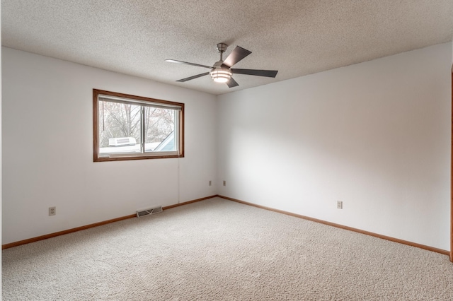 spare room with baseboards, ceiling fan, carpet, and visible vents
