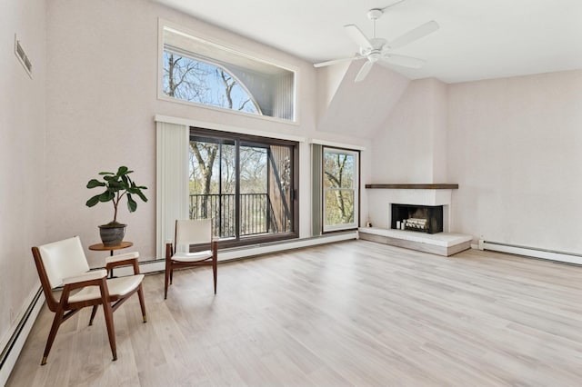 9600 Portland Ave S Unit 322, Bloomington, MN 55420 - living area featuring high vaulted ceiling, a baseboard radiator, light wood-style floors, a fireplace with raised hearth, and a ceiling fan
