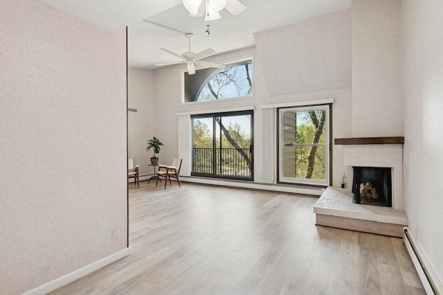 9600 Portland Ave S Unit 322, Bloomington, MN 55420 - living room featuring a baseboard radiator, ceiling fan, wood finished floors, a fireplace, and baseboards