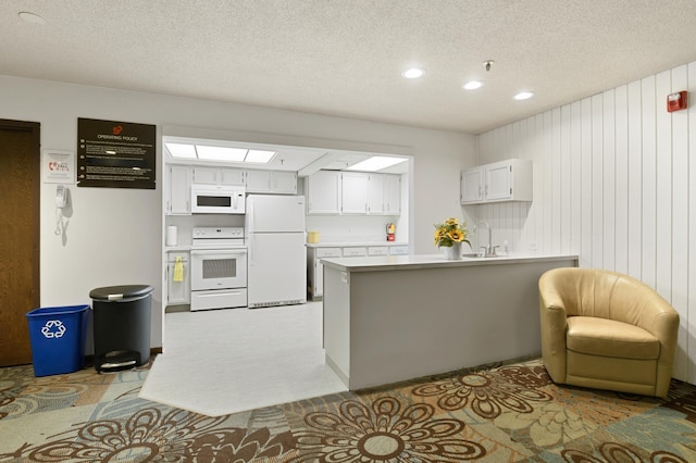9600 Portland Ave S Unit 322, Bloomington, MN 55420 - kitchen with white appliances, a sink, a peninsula, a textured ceiling, and white cabinetry