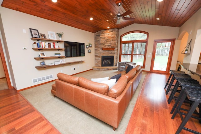 living room with a fireplace, wood finished floors, lofted ceiling, visible vents, and wood ceiling