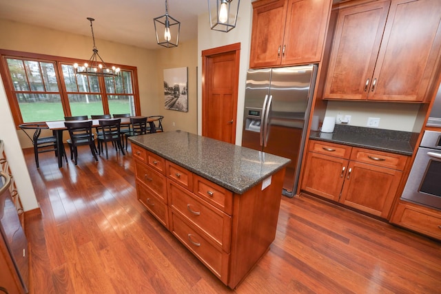 kitchen featuring appliances with stainless steel finishes, brown cabinetry, and dark wood-type flooring