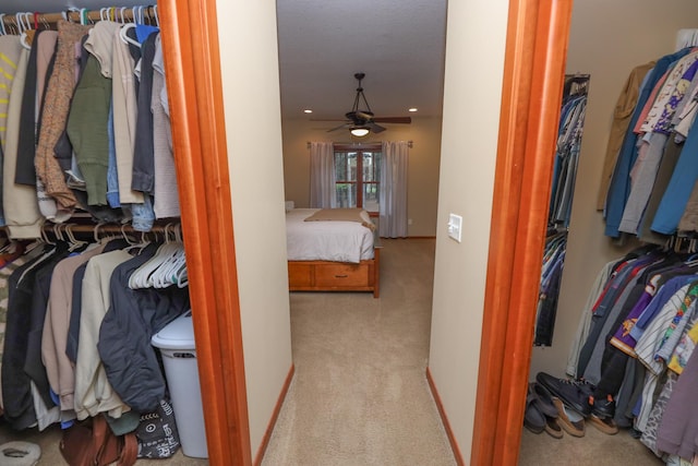 walk in closet featuring carpet floors and a ceiling fan