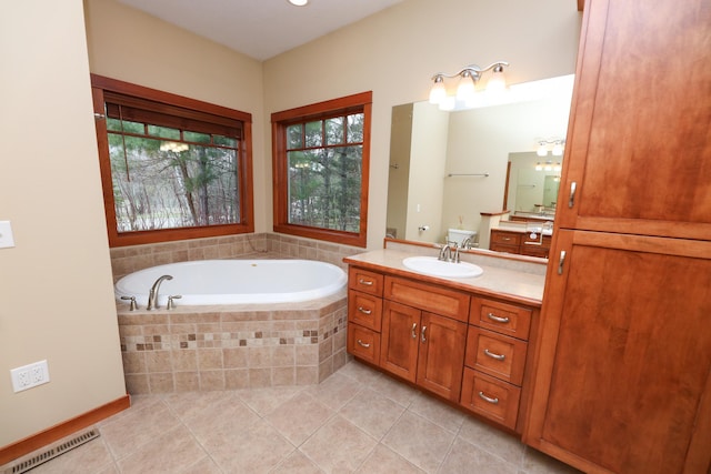 bathroom with tile patterned floors, vanity, a bath, and visible vents