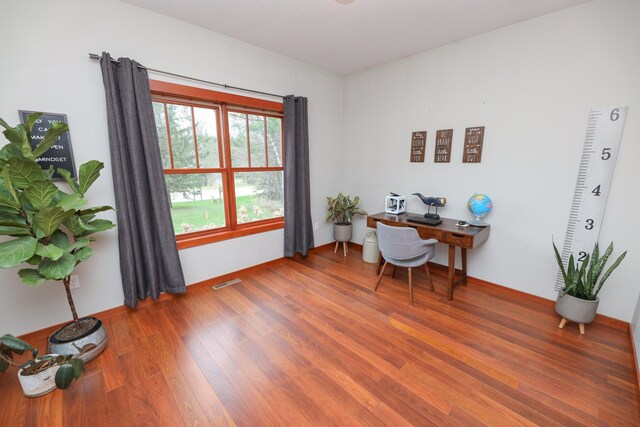 office area with visible vents and wood finished floors