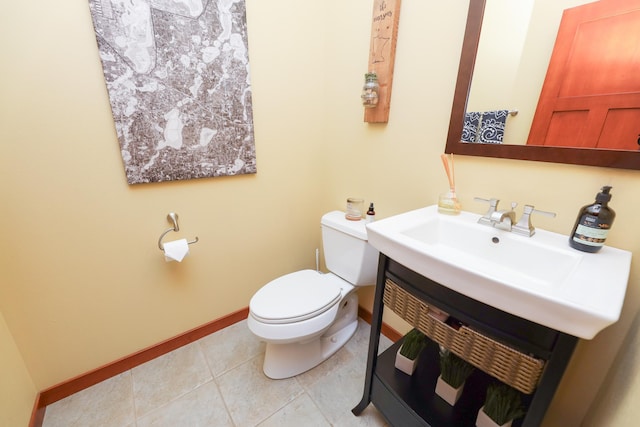 bathroom with baseboards, a sink, tile patterned floors, and toilet