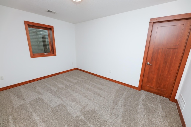 carpeted spare room with baseboards and visible vents