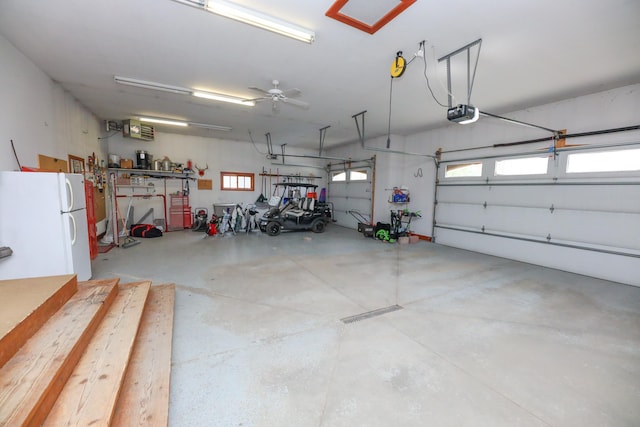 garage featuring freestanding refrigerator and a garage door opener