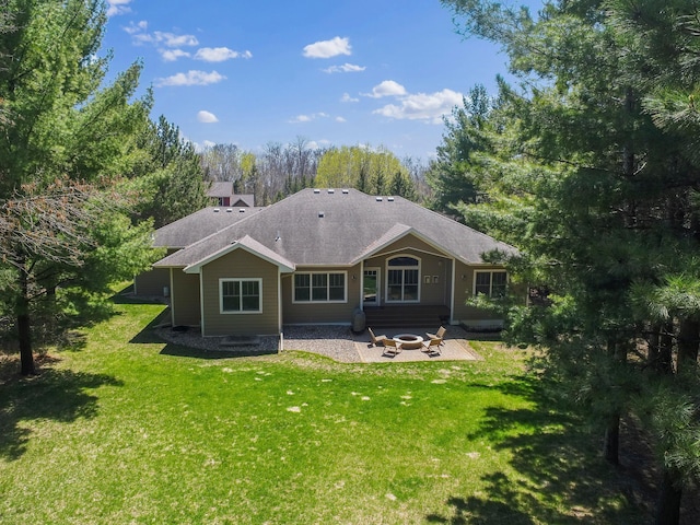 back of property with an outdoor fire pit, a patio area, a shingled roof, and a yard