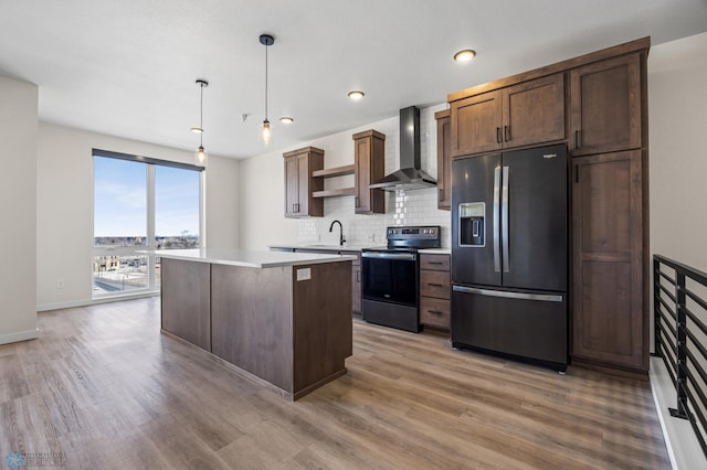kitchen with open shelves, stainless steel fridge, light wood finished floors, electric range oven, and wall chimney exhaust hood