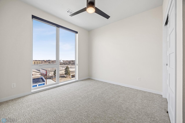 unfurnished bedroom with light colored carpet, baseboards, visible vents, and ceiling fan
