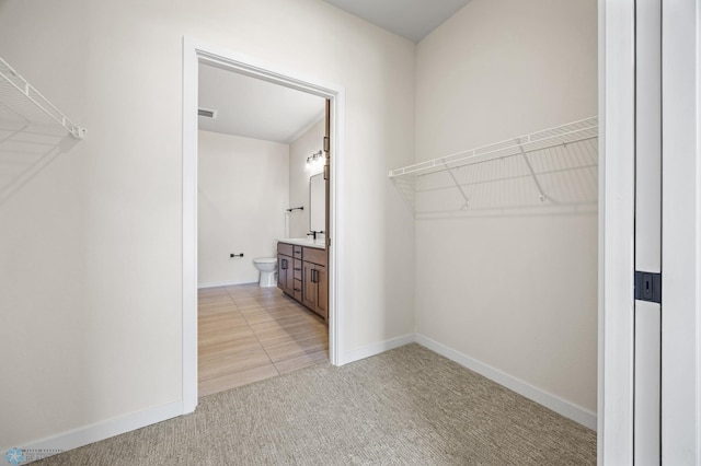 walk in closet featuring visible vents and light carpet
