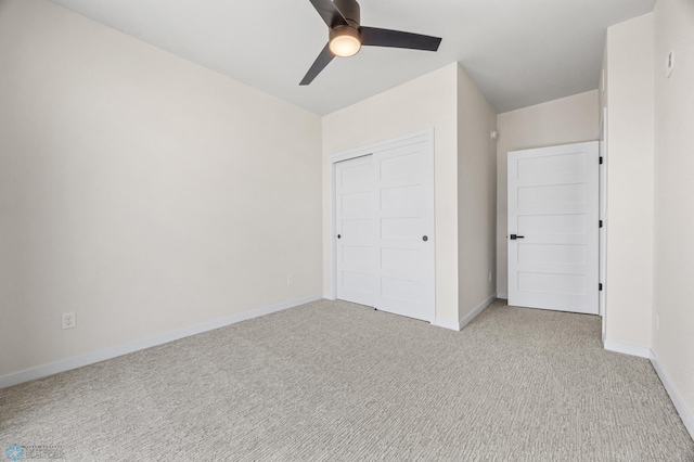 unfurnished bedroom with baseboards, ceiling fan, light carpet, and a closet