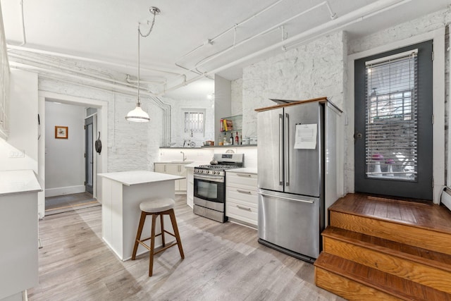 kitchen with appliances with stainless steel finishes, open shelves, light wood-type flooring, light countertops, and white cabinets