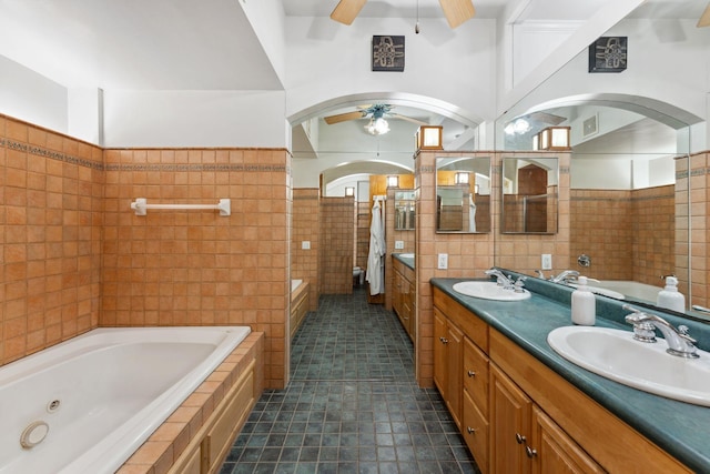 full bath featuring a sink, tile walls, ceiling fan, and tile patterned flooring