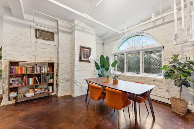 dining room featuring concrete flooring and a wall mounted AC