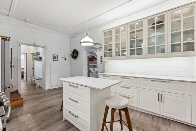 kitchen featuring glass insert cabinets, white cabinets, and wood finished floors