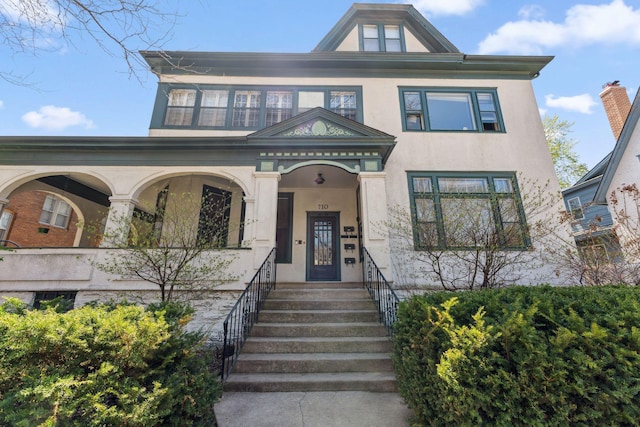 victorian home with a porch and stucco siding