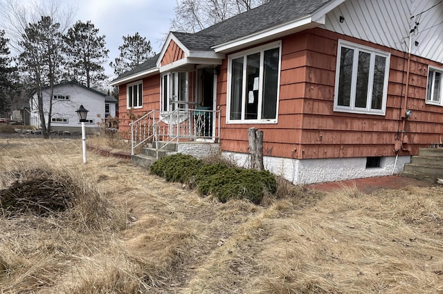 view of side of home featuring roof with shingles