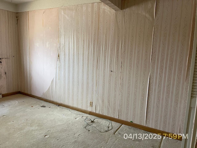 carpeted spare room featuring baseboards and wallpapered walls