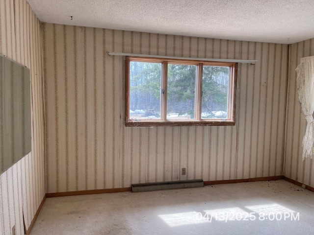 empty room with a healthy amount of sunlight, wallpapered walls, and a textured ceiling