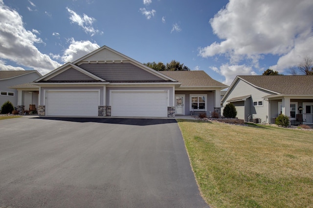 view of front of property featuring a garage, stone siding, a front lawn, and aphalt driveway