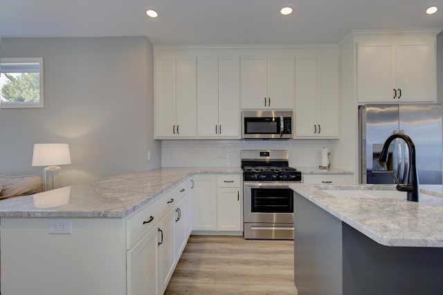 kitchen with stainless steel appliances, recessed lighting, and a peninsula