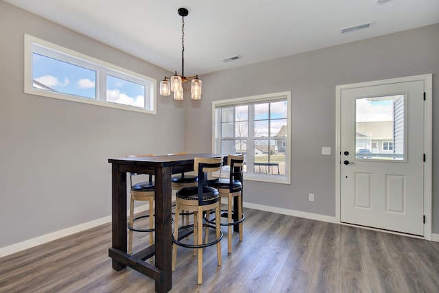 dining area with baseboards, visible vents, plenty of natural light, and wood finished floors