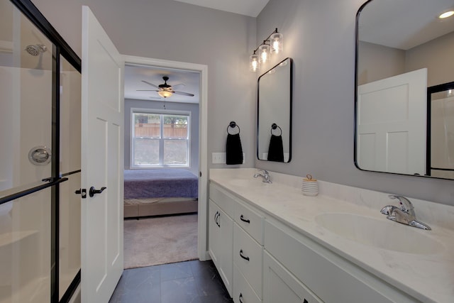 ensuite bathroom with double vanity, a sink, a ceiling fan, and a stall shower