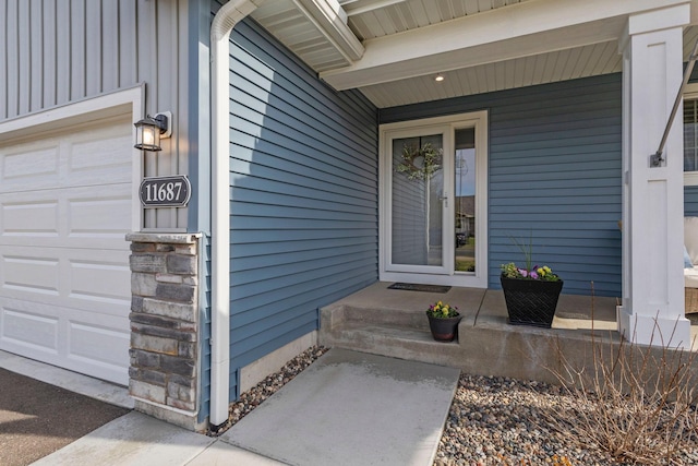 entrance to property with board and batten siding and an attached garage