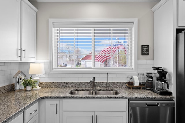 kitchen featuring tasteful backsplash, a sink, light stone counters, white cabinets, and dishwashing machine