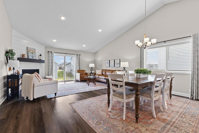dining room featuring a fireplace, wood finished floors, high vaulted ceiling, a chandelier, and recessed lighting