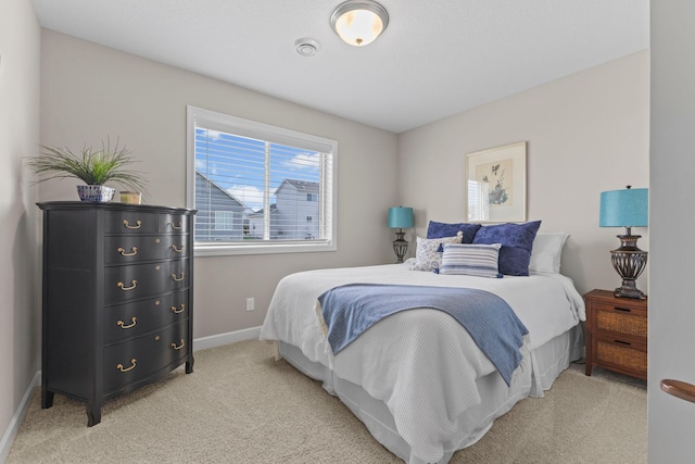 bedroom featuring light colored carpet and baseboards