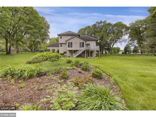 view of yard with fence, stairway, and a deck