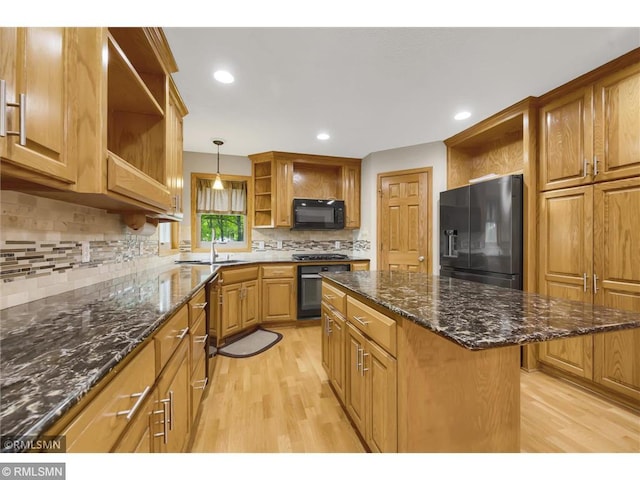 kitchen featuring open shelves, a sink, light wood finished floors, and black appliances