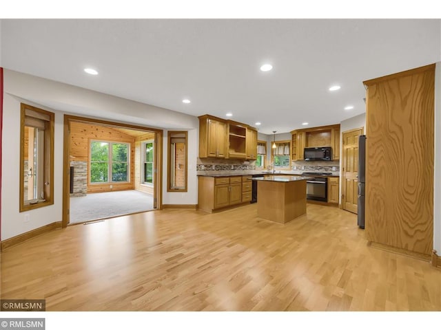 kitchen featuring open shelves, a kitchen island, black microwave, light wood-style floors, and stove