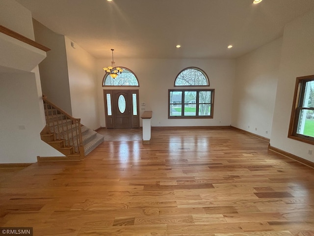 entrance foyer with light wood-style floors, recessed lighting, plenty of natural light, and an inviting chandelier