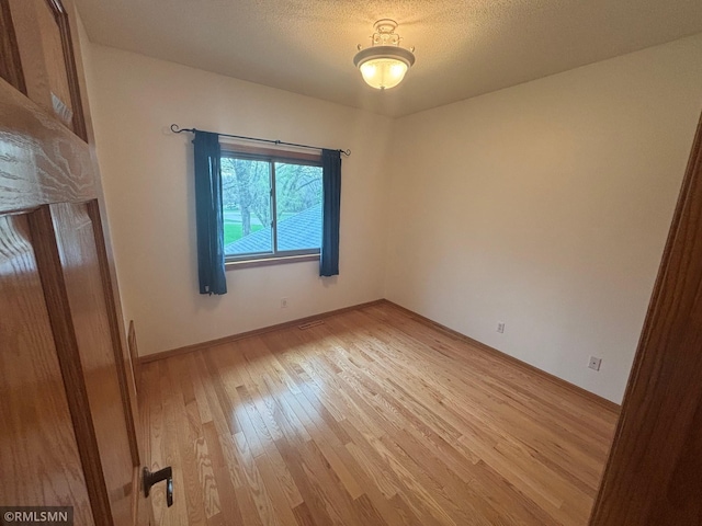 unfurnished room with baseboards and light wood finished floors