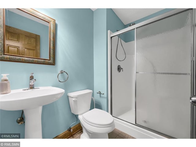 full bath featuring wood finished floors, baseboards, a stall shower, and toilet