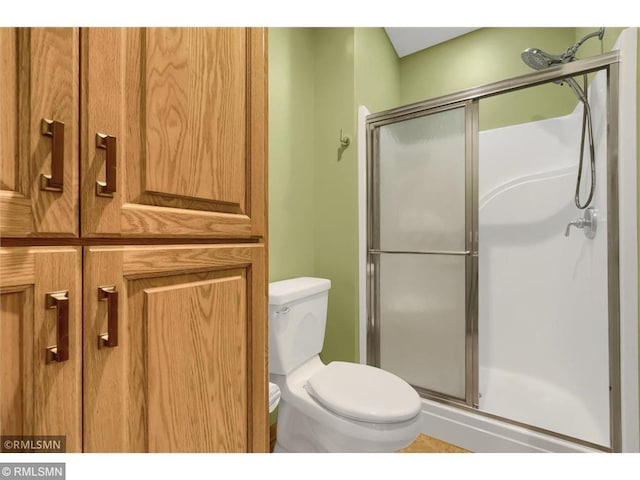 full bathroom featuring toilet and a shower stall