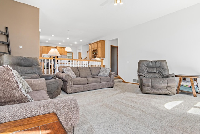 living area with a ceiling fan, visible vents, light colored carpet, baseboards, and recessed lighting