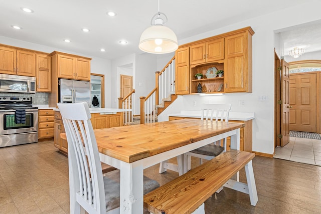 dining space featuring recessed lighting, baseboards, a chandelier, and stairway