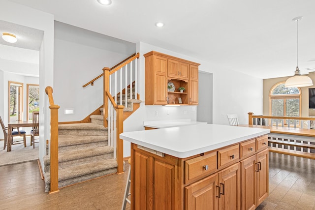 kitchen featuring pendant lighting, a center island, hardwood / wood-style flooring, light countertops, and recessed lighting