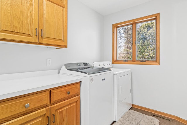 laundry area featuring visible vents, cabinet space, and washing machine and clothes dryer