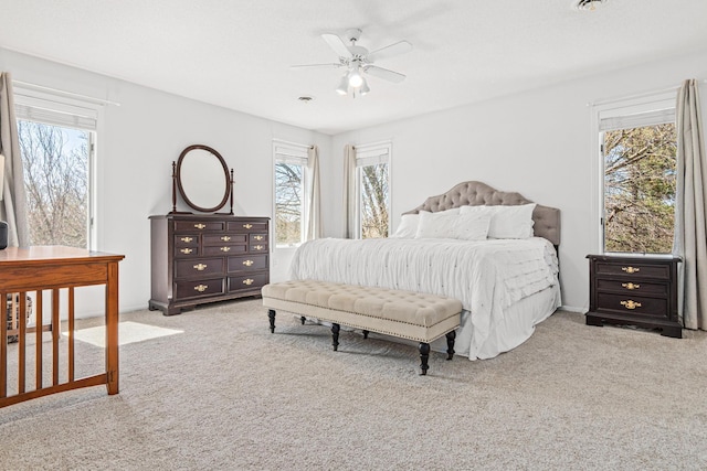 carpeted bedroom featuring a ceiling fan and multiple windows