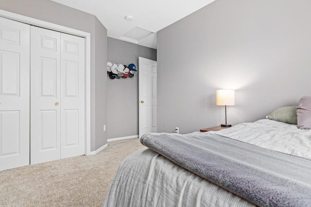 carpeted bedroom with a closet and baseboards